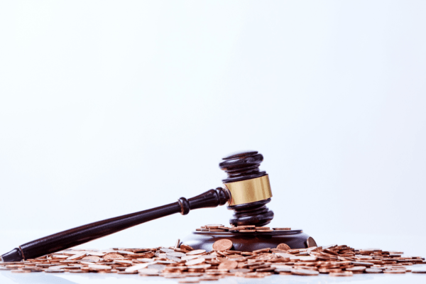 Wooden gavel on pile of coins representing can you deduct legal fees for tax
