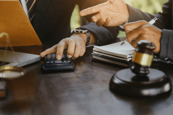 Professional tax lawyer consultation showing calculator, legal documents and gavel representing does a tax lawyer go to court scenarios