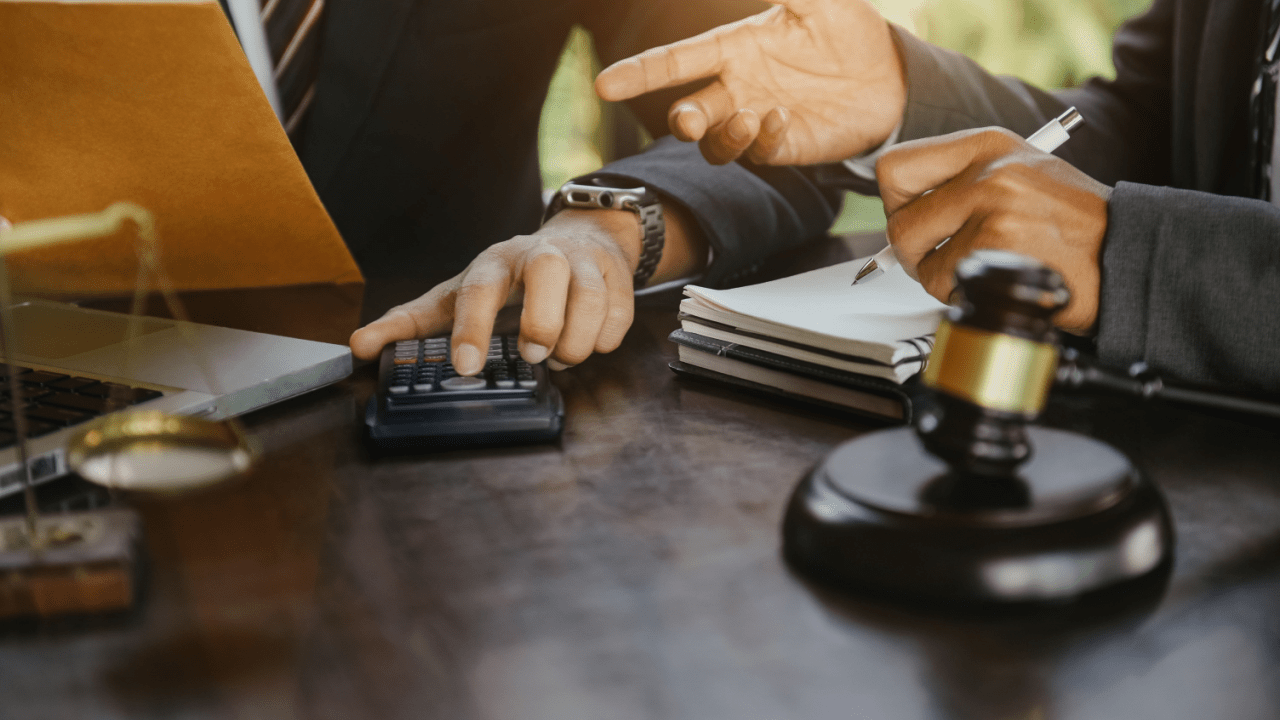 Professional tax lawyer consultation showing calculator, legal documents and gavel representing does a tax lawyer go to court scenarios