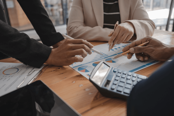 Tax professionals analyzing specialized IRS and tax problem topics with financial charts and calculator during consultation meeting