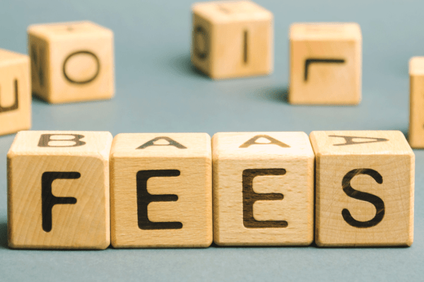 Wooden blocks spelling FEES representing hourly rates vs flat fees for tax lawyers pricing decision
