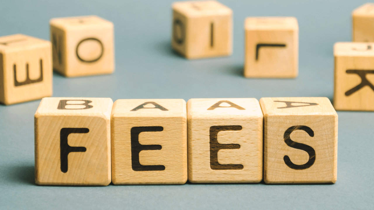 Wooden blocks spelling FEES representing hourly rates vs flat fees for tax lawyers pricing decision