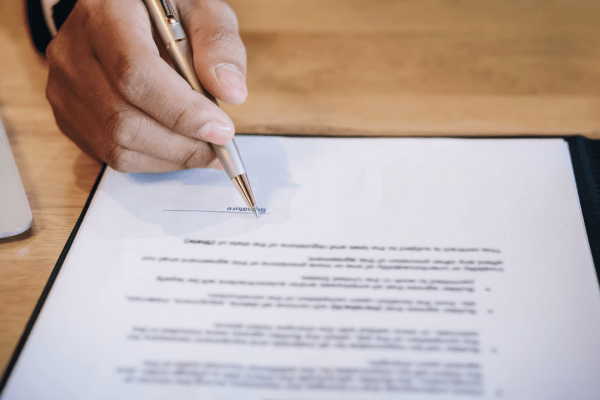 Professional signing legal documents with an IRS audit defense attorney for tax resolution services