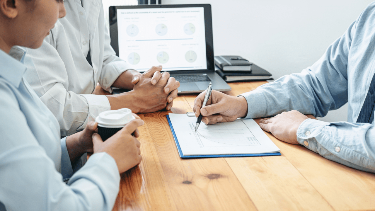 Professional tax consultant reviewing IRS settlement and offer in compromise documents with clients during financial consultation meeting