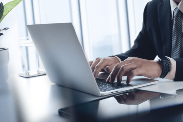 Business professional in suit working on laptop researching tips for choosing the right tax lawyer