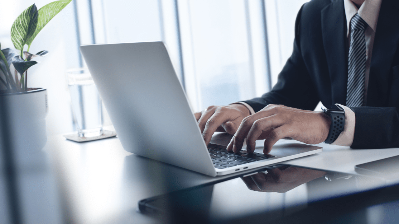 Business professional in suit working on laptop researching tips for choosing the right tax lawyer