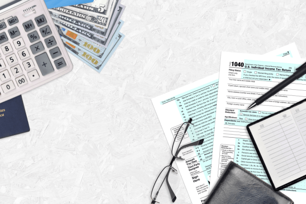 Tax documents, calculator, cash and passport representing when you need a tax attorney for wage garnishment issues