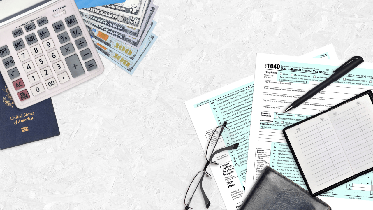 Tax documents, calculator, cash and passport representing when you need a tax attorney for wage garnishment issues