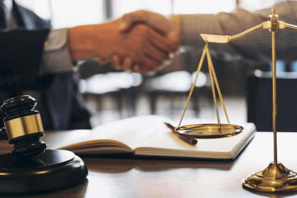 Legal consultation scene showing scales of justice and gavel representing what is the difference between a tax attorney and a tax lawyer