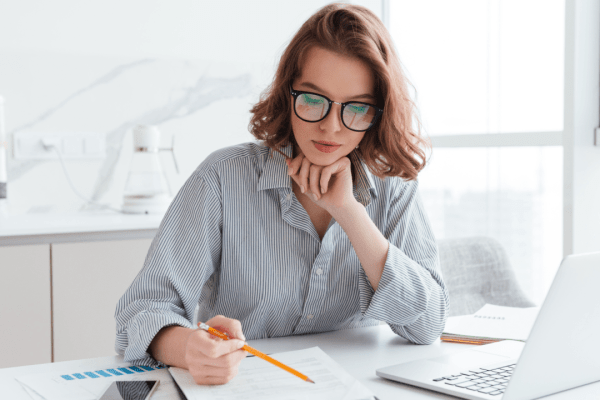 Woman researching what is the IRS 7 year rule for tax debt relief while reviewing financial documents at home office desk