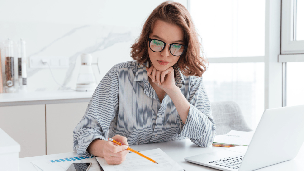 Woman researching what is the IRS 7 year rule for tax debt relief while reviewing financial documents at home office desk