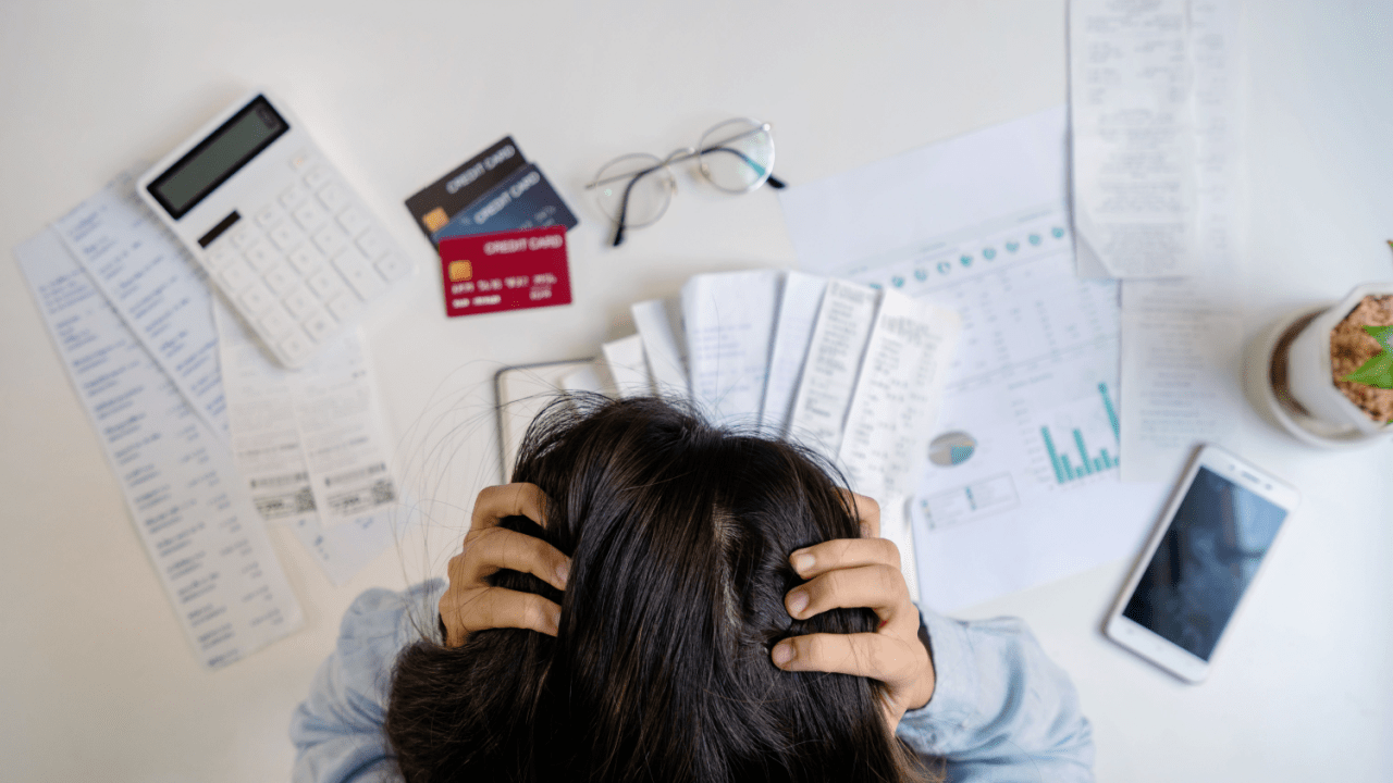 Person overwhelmed by bills showing what happens if you lose your job and cant pay your bills