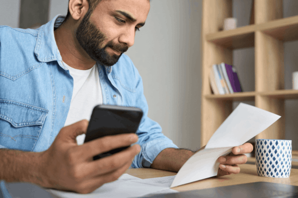Man reviewing tax documents while researching does IRS offer payment plans on smartphone