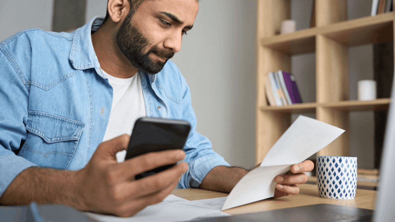 Man reviewing tax documents while researching does IRS offer payment plans on smartphone
