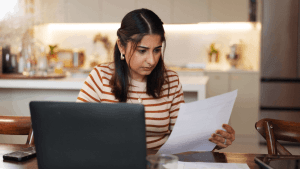 Woman researching does the IRS forgive tax debt after 7 years while reviewing financial documents at home