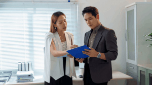 Business professionals reviewing documents about how much can you pay your spouse tax free in office setting