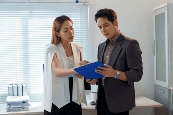 Business professionals reviewing documents about how much can you pay your spouse tax free in office setting