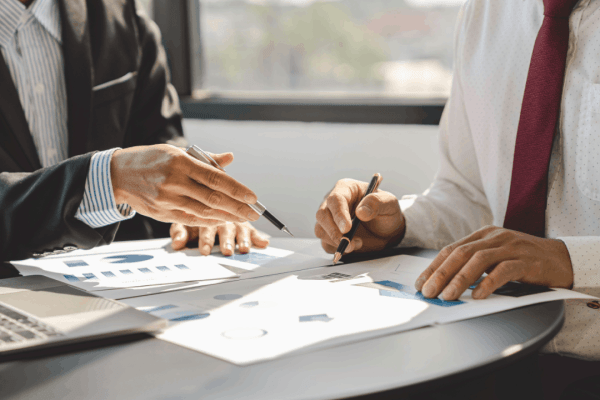 Financial advisor explaining IRS hardship and payment plans to client reviewing tax documents with charts