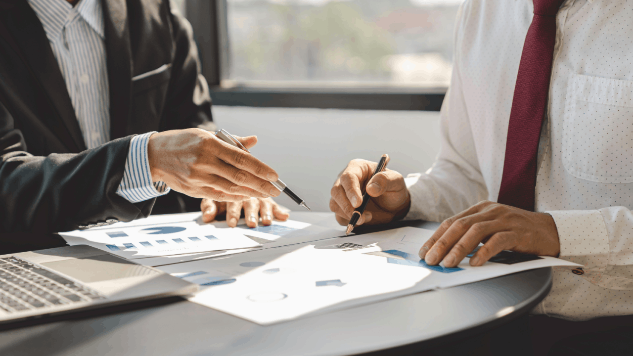 Financial advisor explaining IRS hardship and payment plans to client reviewing tax documents with charts