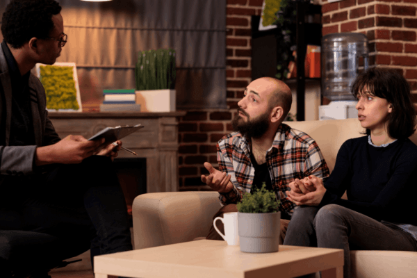 Couple seeking innocent spouse relief guidance from tax professional during home consultation about IRS tax liability