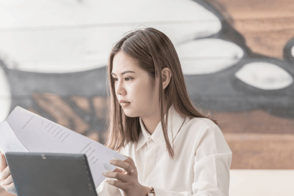 Woman reviewing financial documents to determine what debts are eligible for forgiveness through tax relief programs