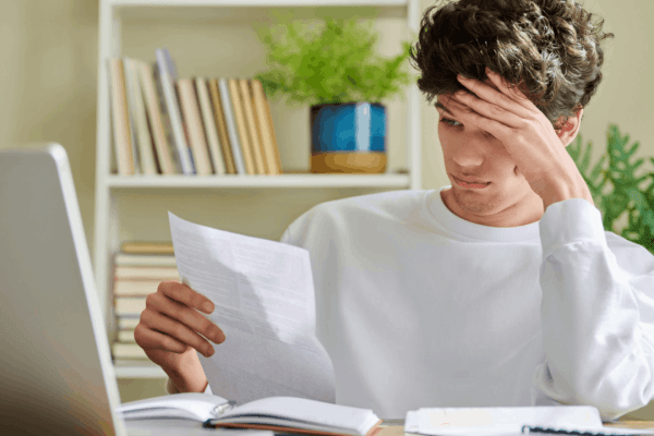 Stressed taxpayer reviewing IRS documents wondering what IRS debts are eligible for forgiveness