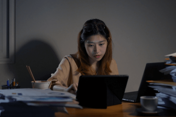 Woman researching what is the 3 year rule for the IRS on tablet while reviewing tax documents at desk