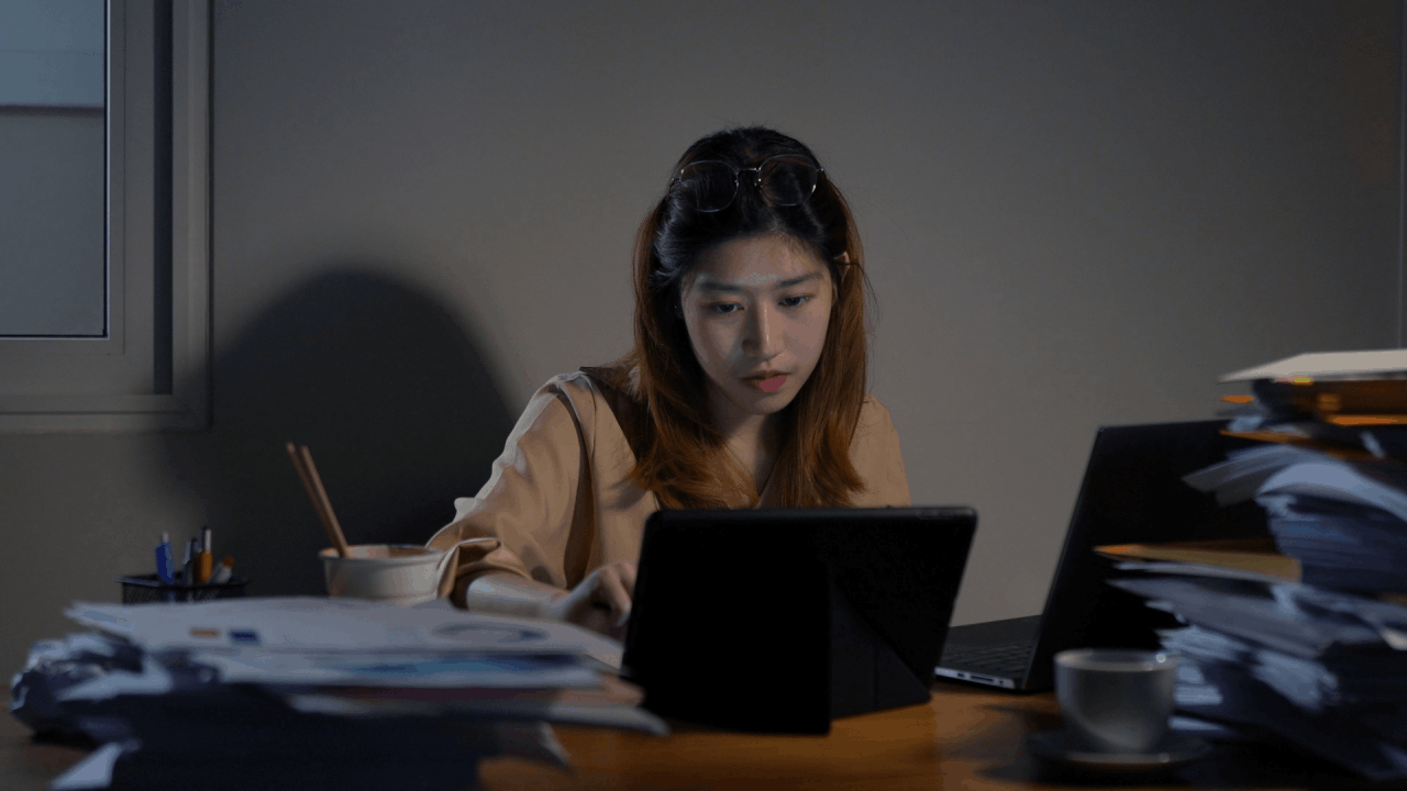 Woman researching what is the 3 year rule for the IRS on tablet while reviewing tax documents at desk