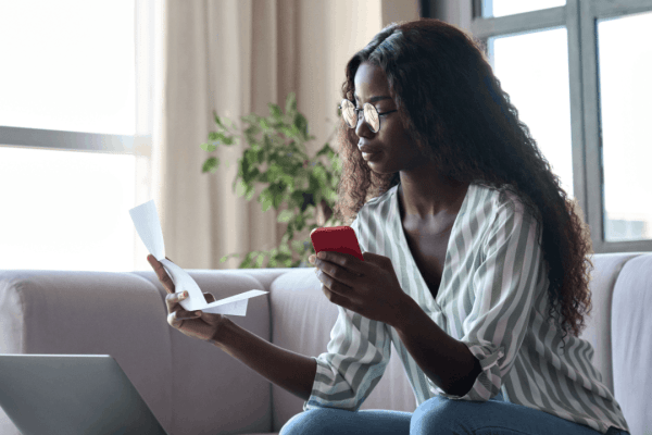 Woman reviewing tax documents while researching what is the IRS 3-year rule on her phone