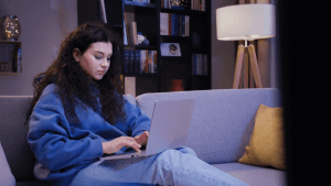 Woman researching who is responsible for IRS debt in a divorce on laptop at home in evening