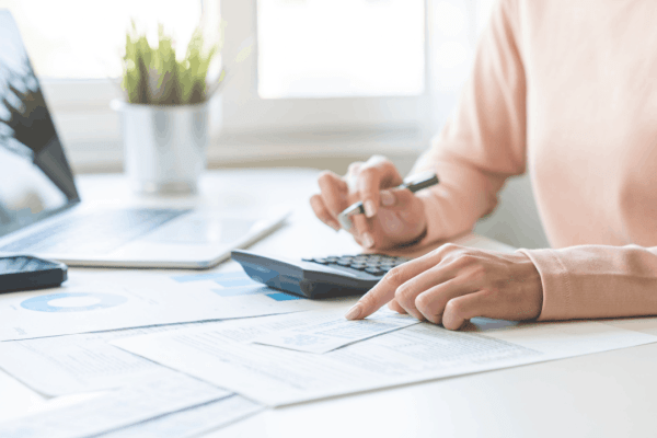 Executor reviewing deceased estate tax documents with calculator to understand 3-year rule for deceased estate filing deadlines