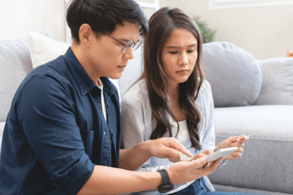 Couple reviewing tax documents together discussing am I liable for my husband's tax debt concerns