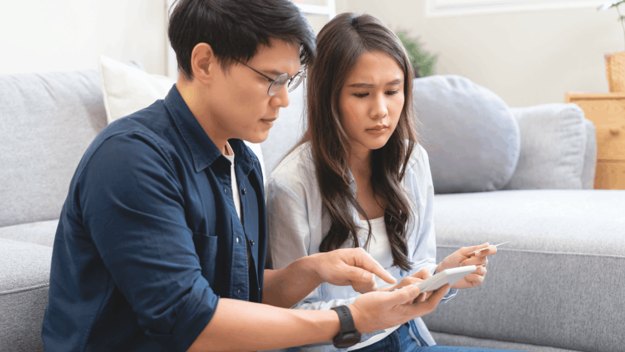 Couple reviewing tax documents together discussing am I liable for my husband's tax debt concerns