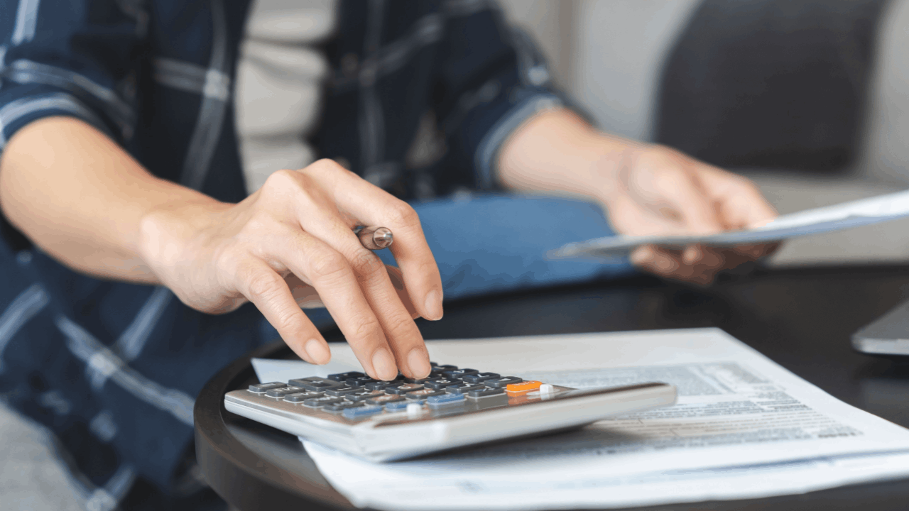 Does the IRS forgive debt after 10 years - taxpayer calculating tax debt with documents and calculator