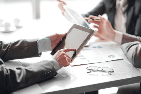 Tax professionals discussing how hard it is to get innocent spouse relief while reviewing case requirements and eligibility criteria on a tablet