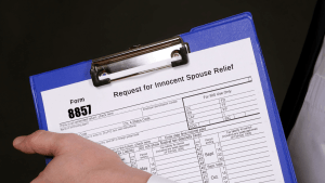 How to win innocent spouse relief Form 8857 request on clipboard showing IRS tax debt relief application