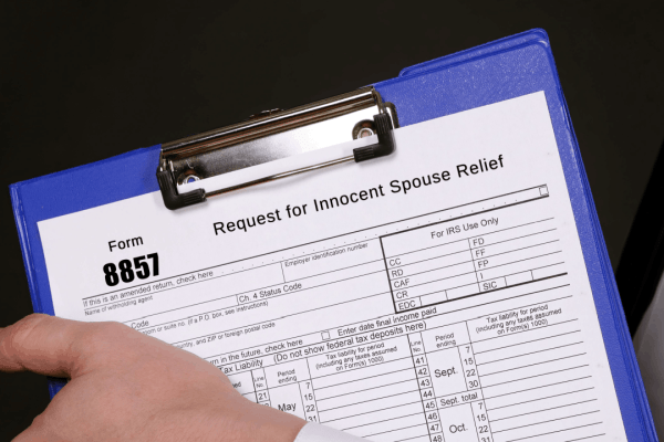 How to win innocent spouse relief Form 8857 request on clipboard showing IRS tax debt relief application