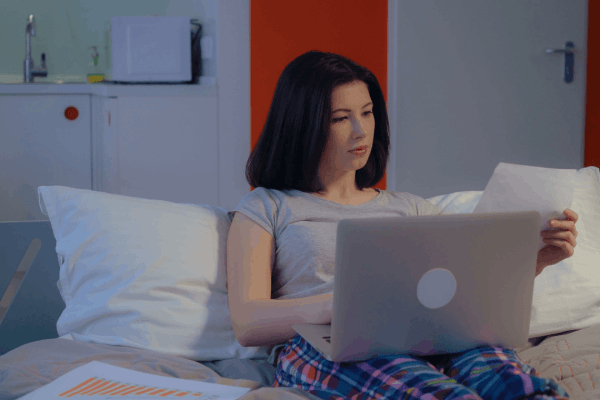 Woman researching what form do you use for an innocent spouse on laptop while sitting in bed