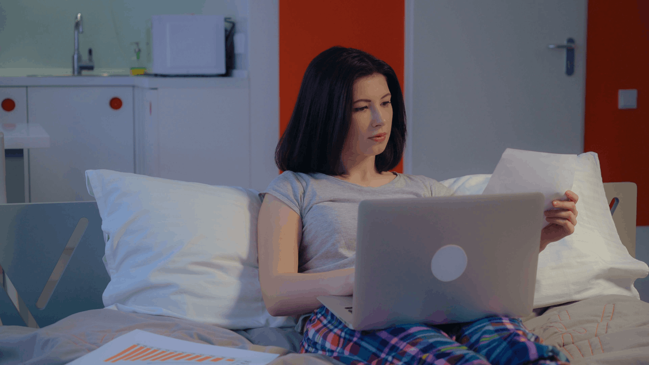 Woman researching what form do you use for an innocent spouse on laptop while sitting in bed