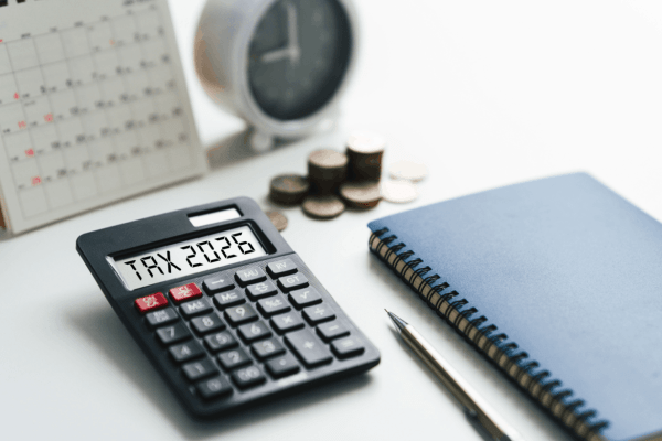 Am I in trouble if I get audited — calculator displaying TAX 2026 with coins, clock, and notebook representing IRS audit preparation