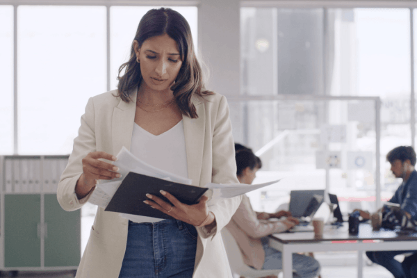 Woman reviewing tax audit documents in a modern office, concerned about IRS audit findings