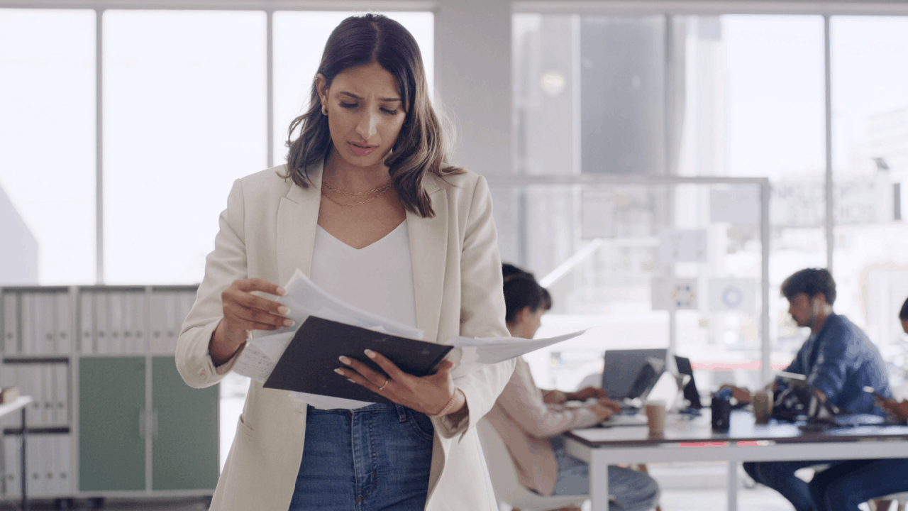 Woman reviewing tax audit documents in a modern office, concerned about IRS audit findings