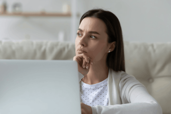 Concerned woman sitting with laptop wondering how likely are my taxes to be audited while reviewing financial documents