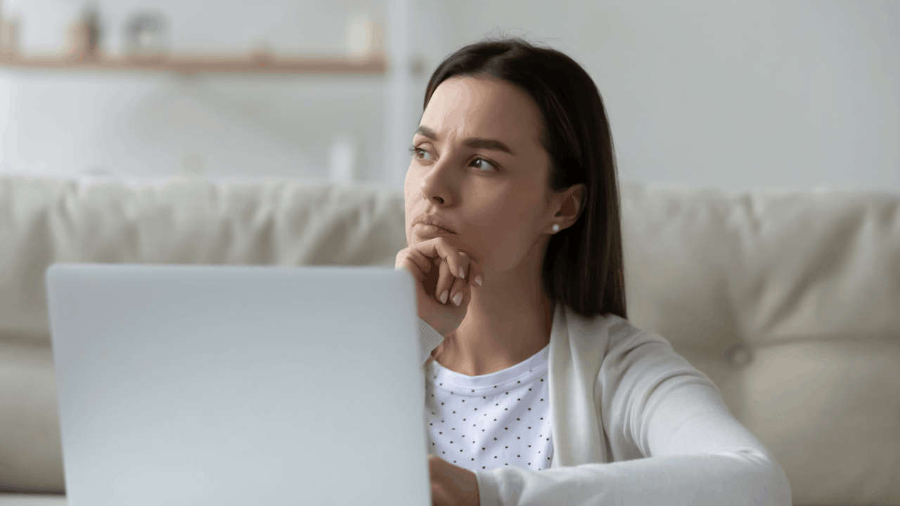 Concerned woman sitting with laptop wondering how likely are my taxes to be audited while reviewing financial documents