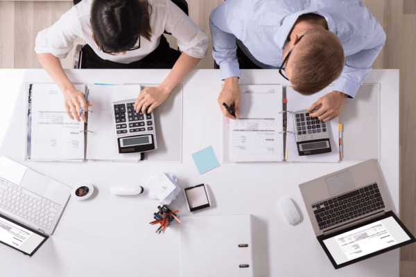 Two tax professionals reviewing audit documents and invoices, representing how long a tax audit usually takes