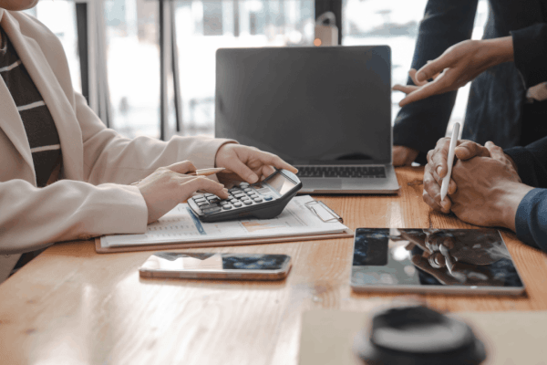 Two professionals reviewing tax documents and using a calculator during an IRS audit consultation meeting
