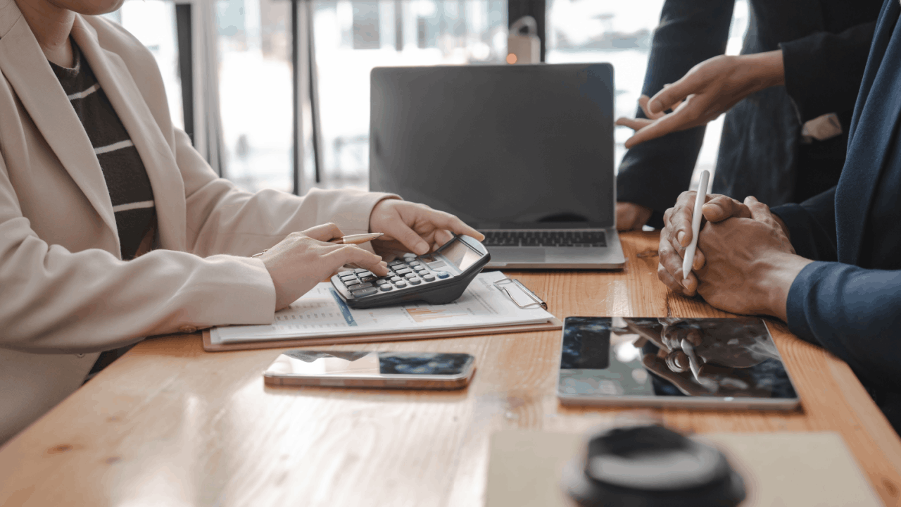 Two professionals reviewing tax documents and using a calculator during an IRS audit consultation meeting