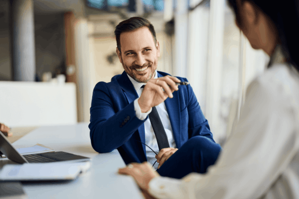 Confident tax professional smiling during a tax audit consultation meeting with clients in a modern office