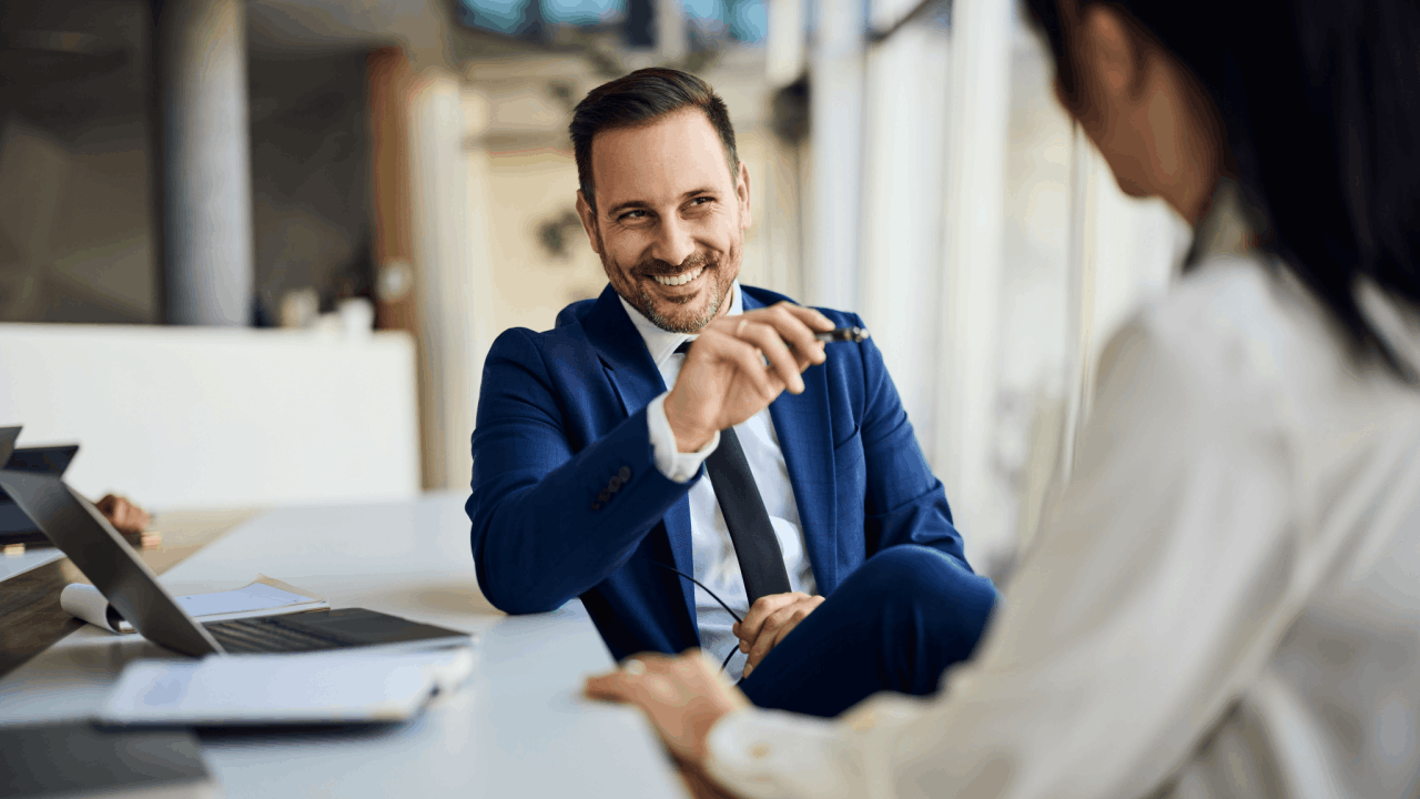 Confident tax professional smiling during a tax audit consultation meeting with clients in a modern office