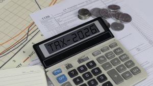 Calculator displaying TAX-2026 surrounded by IRS Form 1120 and coins — illustrating what are the odds of being audited by the IRS in 2026